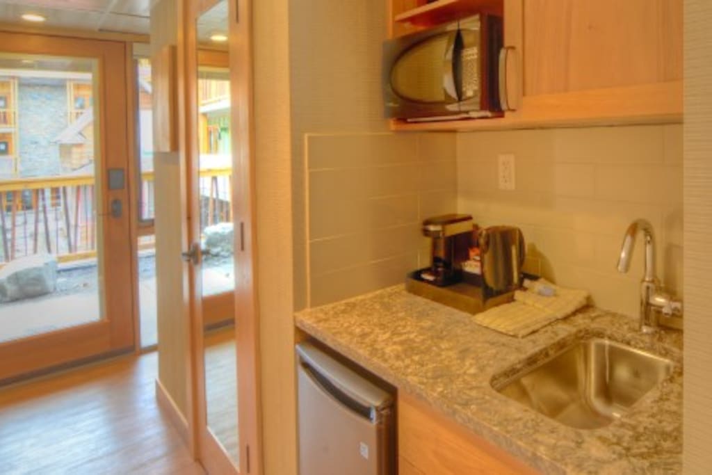 The suite includes a small kitchenette with a sink and fridge