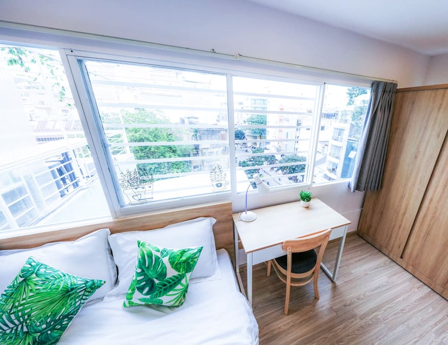 rooftop bedroom with large windows providing city view