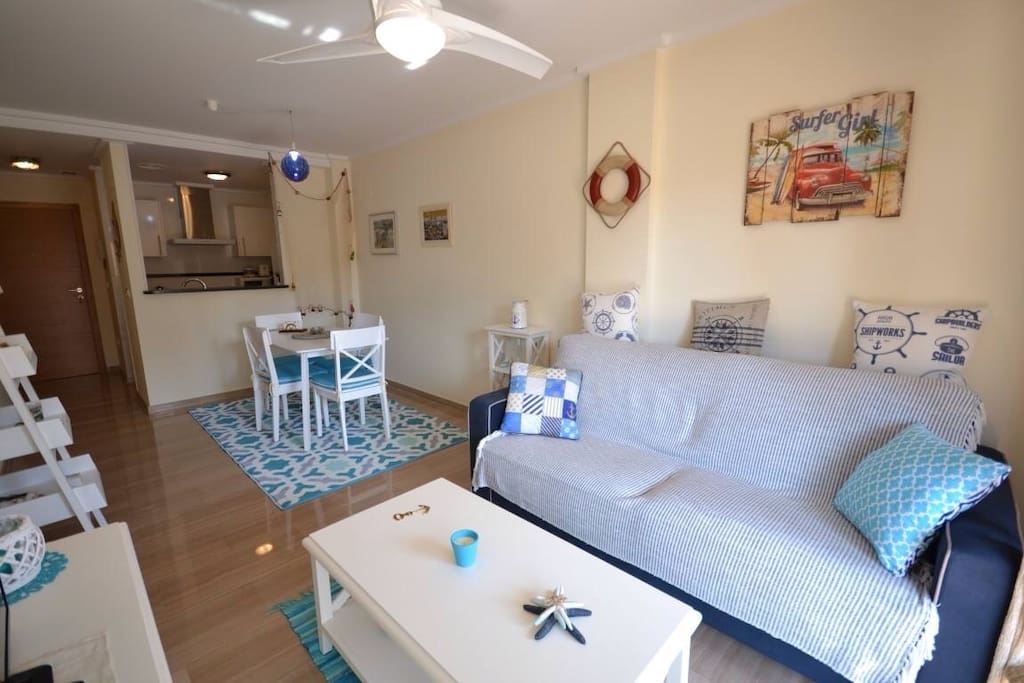 Salón / comedor con sofa cama, televisión, mesa con 4 sillas y cocina americana equipada con nevera, horno, microondas y lavadora. Aire acondicionado frío/ calor por conducto en toda la vivienda.