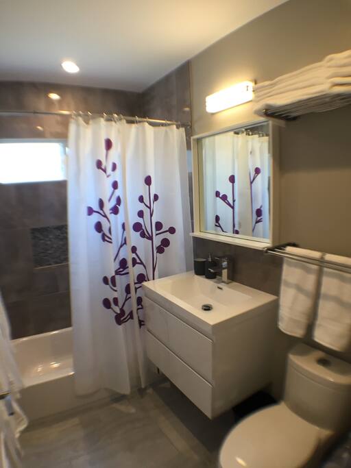 Fully remodeled, clean, contemporary bathroom with lots of hot water and many white towels