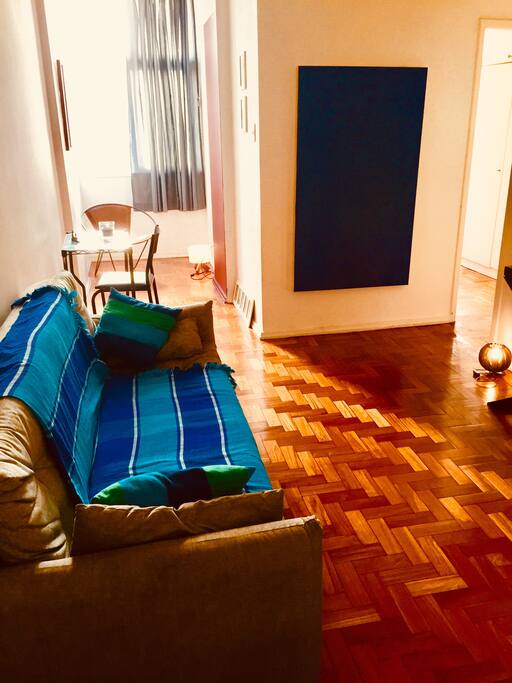 Sala com sofá-cama vista da entrada do apartamento