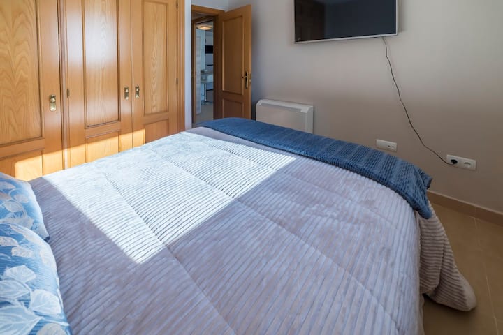 Spálňa 1, 1,35 manželská posteľ, 1. kvalitný matrac. Televízor, šatník s vešiakmi na uloženie oblečenia.