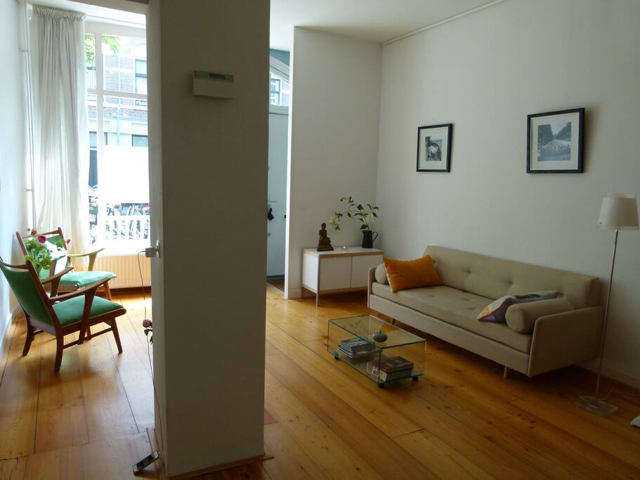 Spacy livingroom with heigh ceiling and large windows. Convertible couch for one person