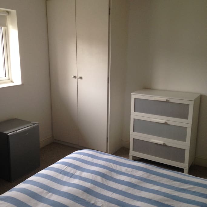 wardrobe, chest of drawers + fridge in room