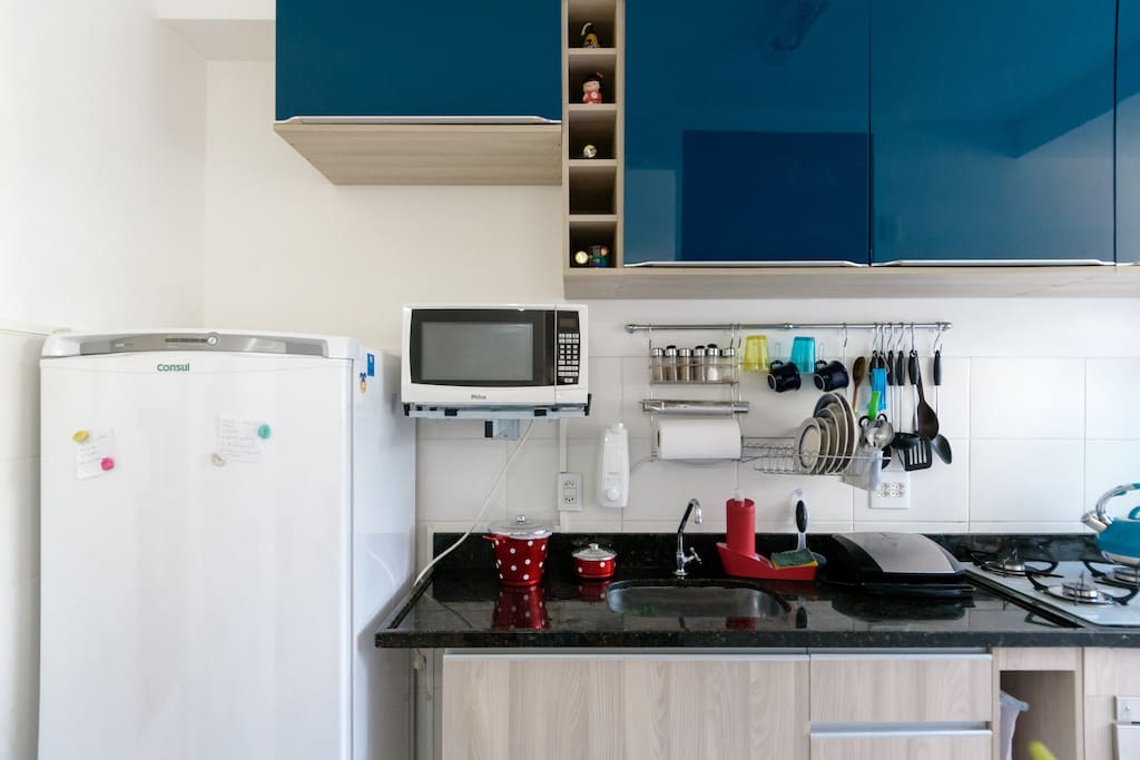 Cozinha americana com cooktop e forno embutido.