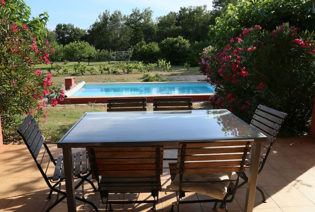 Une terrasse ombragée avec vue sur la piscine.