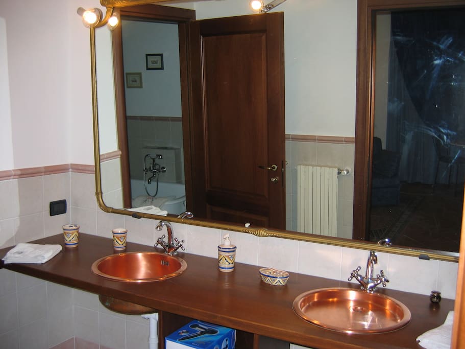 Bagno della junior suite con doppio lavabo in rame e servizio di cortesia completo