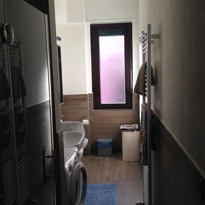 bathroom with shower, washing machine, toilet, bidet and washbasin