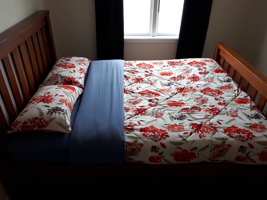 Bedroom 2. One Queen Bed, desk, chair, draws, mirror and bedside lamp.