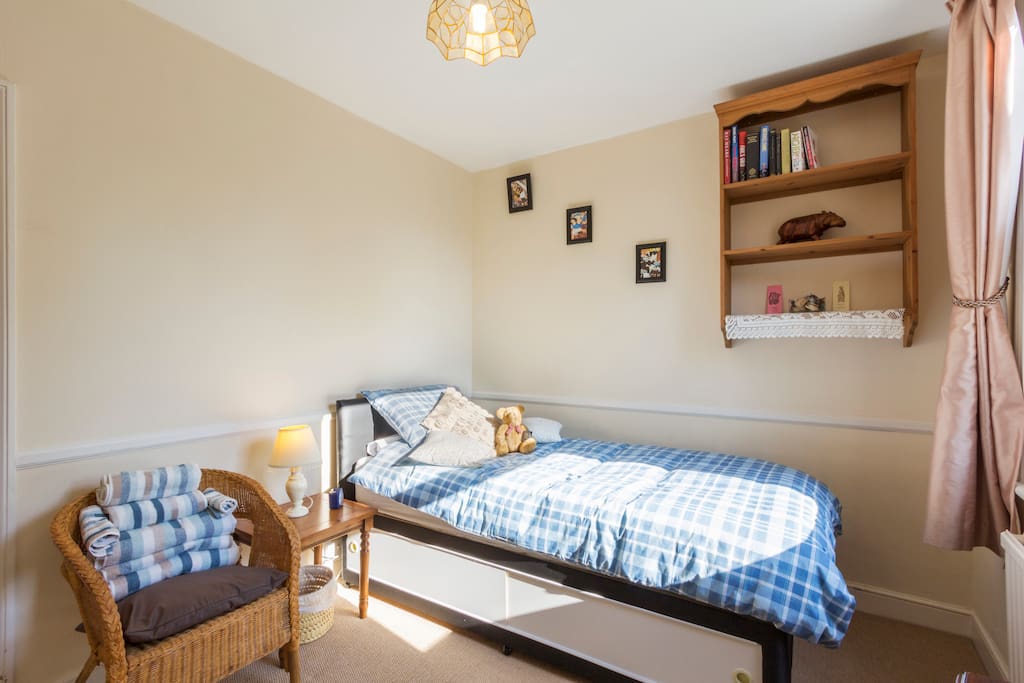 Our comfortable single bed, towels, chair & bookcase.