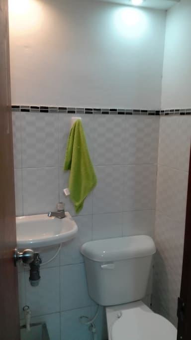 Baño privado con elementos de aseo y toalla. / Private bathroom with toiletries and towel.