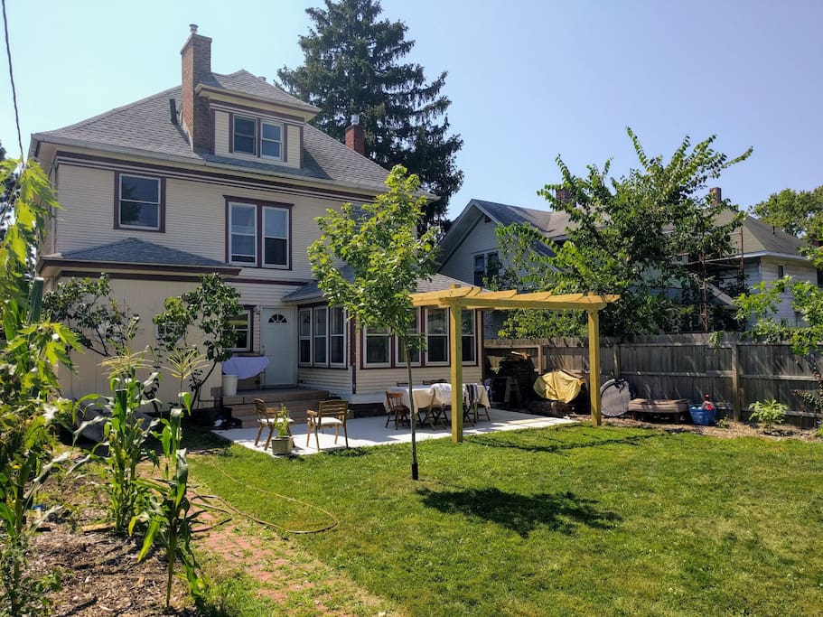 Backyard with pergola, portable firepit, table and chairs, small charcoal grill, sandbox and other games/activities available.