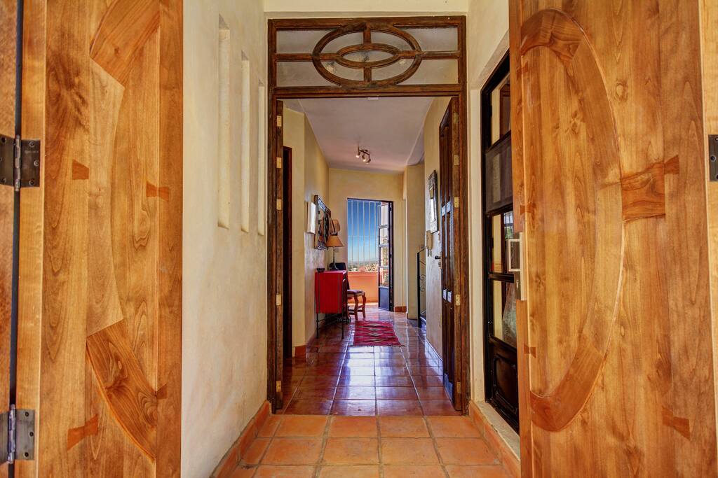 The front door leads to The View, beyond. The colorful, tiled Entry Hall connects both bedrooms and the study. A stair on the right leads upstairs and down.