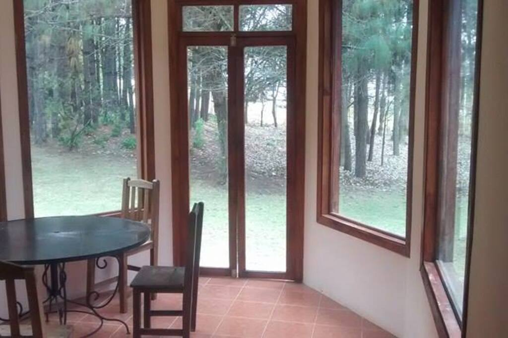 Desayunador rodeado de ventanales que permiten una vista maravillosa del bosque