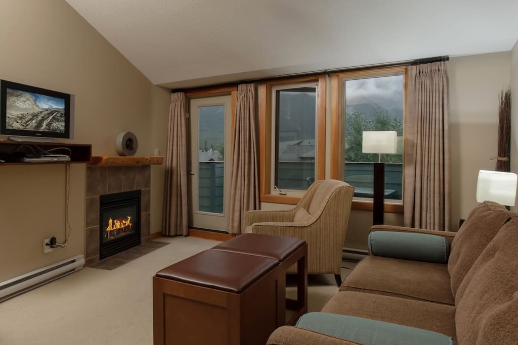 Featuring stylish furnishings around the stone-framed fireplace and TV