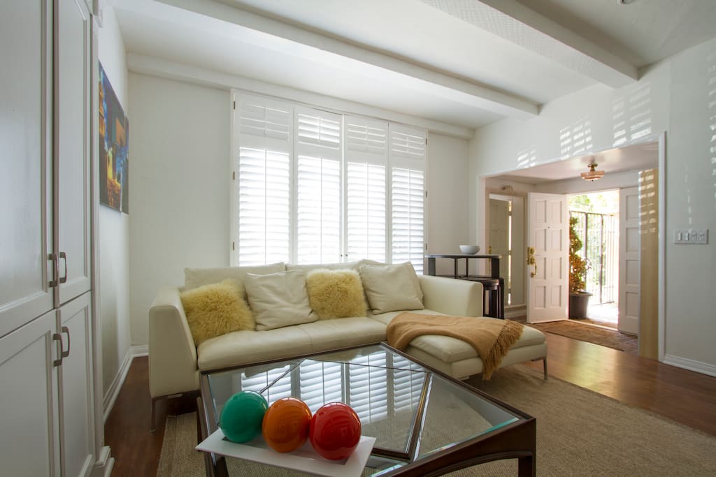 Spacious living room with cozy high-end furnishings. Entry foyer leads to private patio