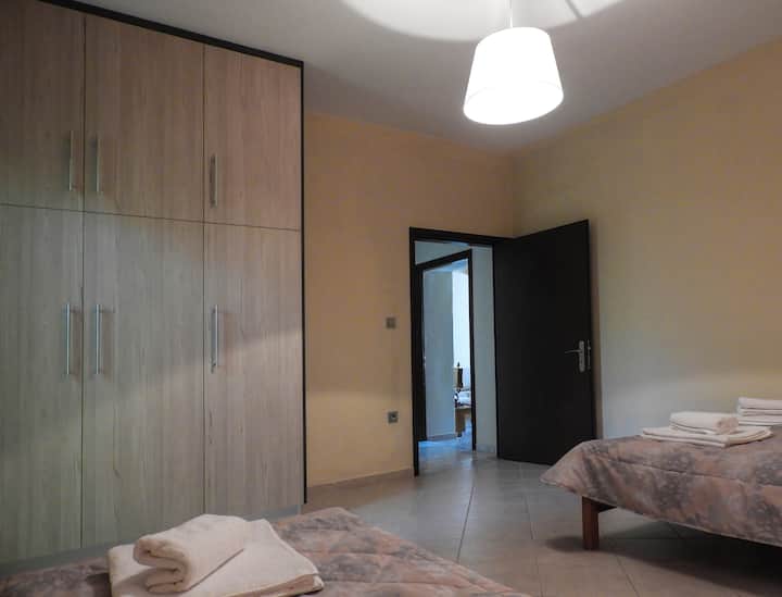 ห้องนอนพร้อมเตียงใหญ่และเตียงเดี่ยวและตู้เสื้อผ้า