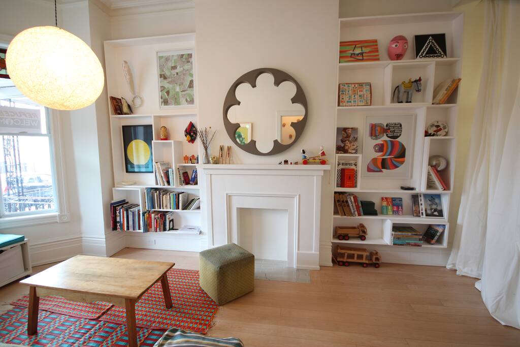 Living room display shelves filled with art & design books, prints, and other curios