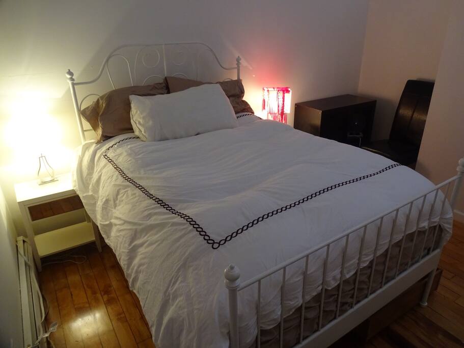 There are 2 night stands, 2 lamps, a low bookcase and chair. There's an ottoman with storage where you can keep your suitcase, and a hue closet is in the corner.