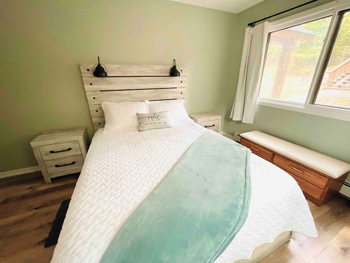Dormitorio 1: piso principal. Cama matrimonial.  Dos grandes ventanales con vistas arboladas. 