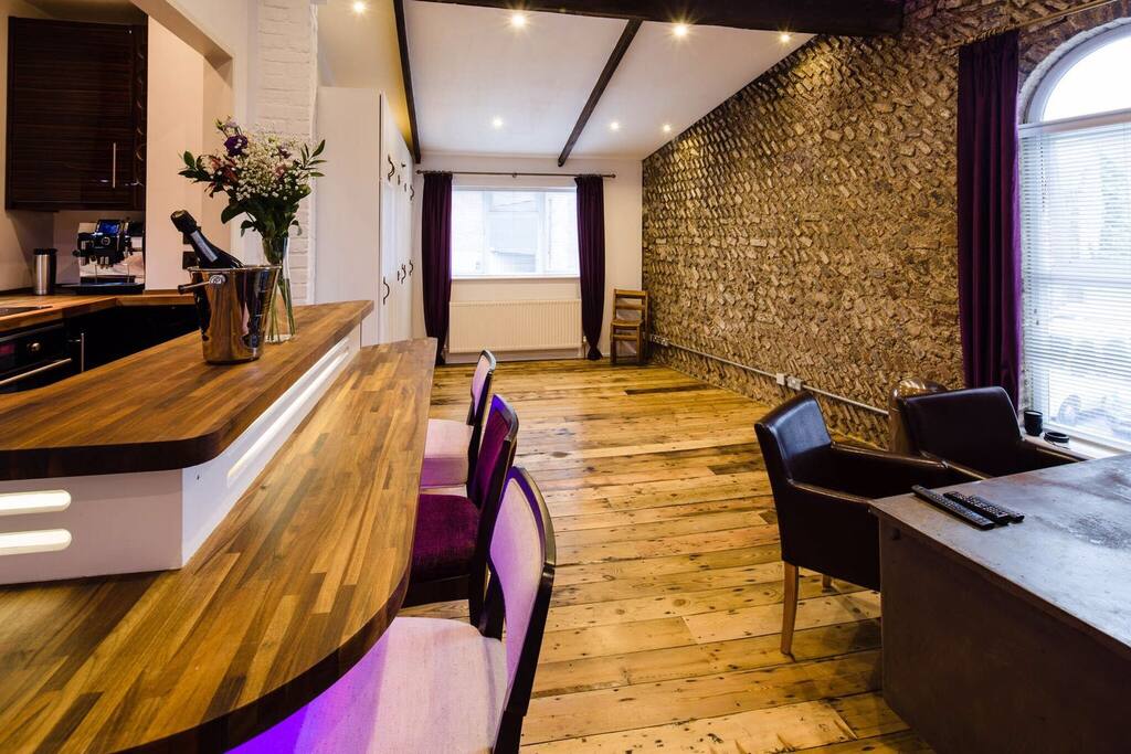 split level bar + open plan kitchen with 4 stools and mood lighting.