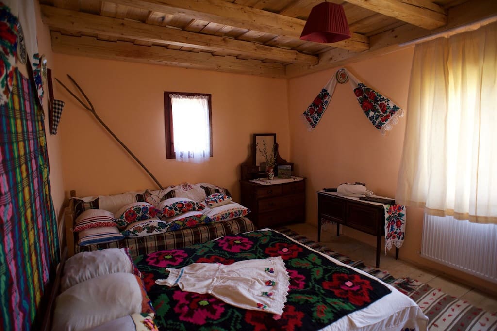Large double room with hand embroidered linen, pillow cases, bed spread and petticoat. Natural-dye floor coverings are known as 'țoluri'.