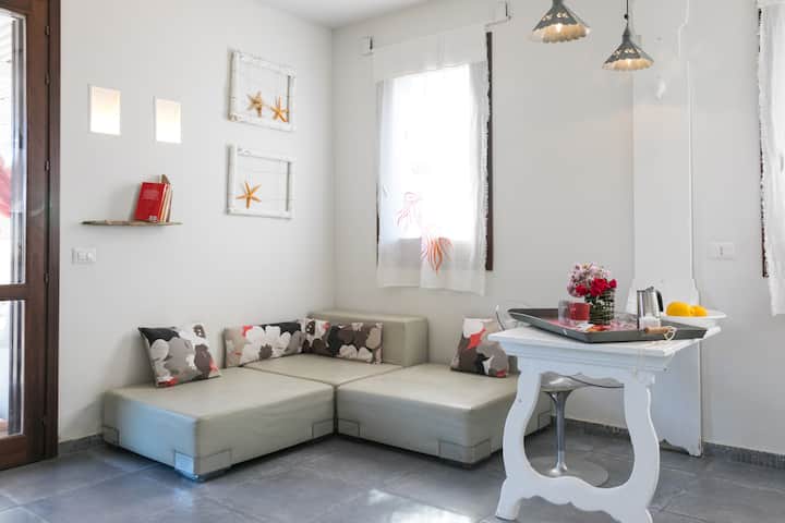 dnevni boravak s Kartell kaučem i izlazom iz vanjskog vrta pored sjenice