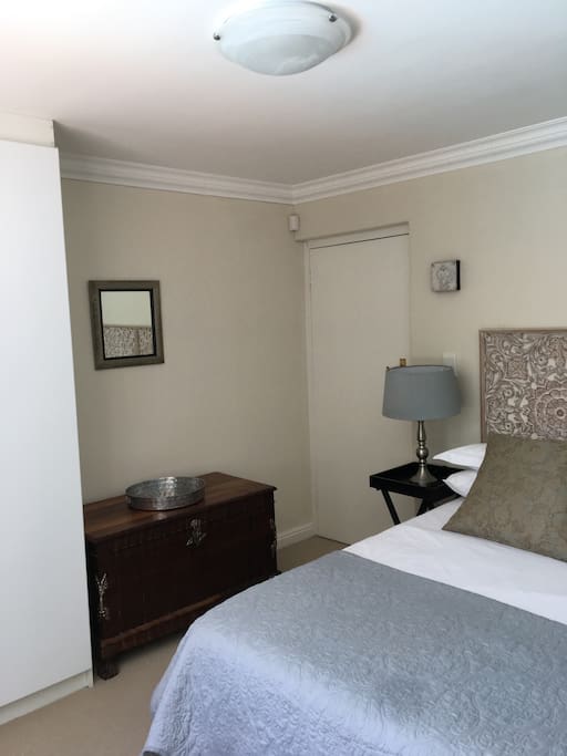 The main bedroom features a double wardrobe with hanging and shelf space, as well as a chest of three drawers.