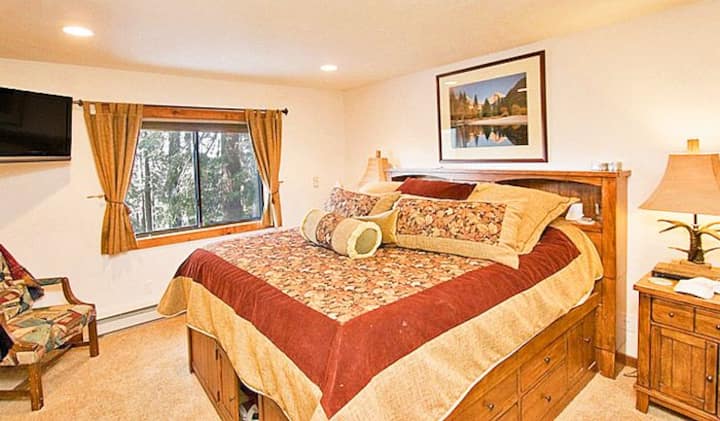 La chambre principale king size dispose d'une grande fenêtre qui apporte de la lumière naturelle et offre une vue, ainsi qu'une télévision pour plus de confort.