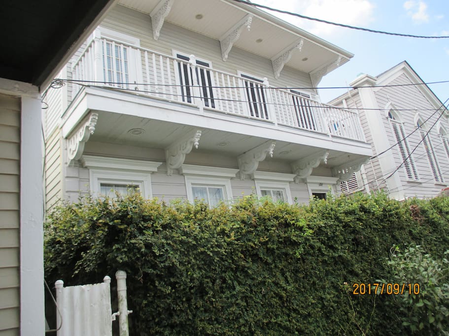 Front View of the House with a High Hedge, with seasonal flowers