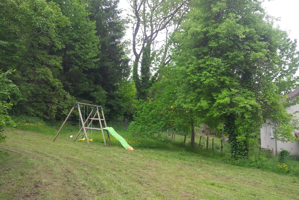 Grand jardin avec balançoire et toboggan