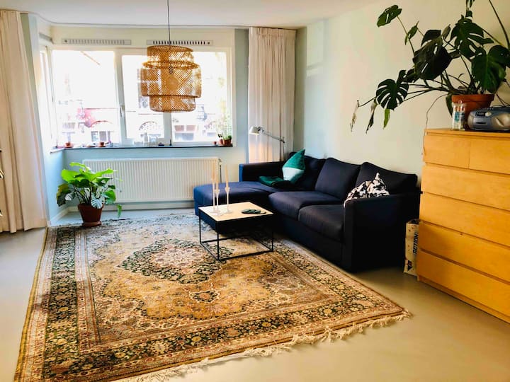 Living room with couch for 3 persons and view on the river Amstel 