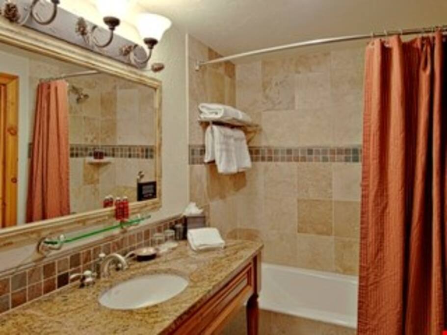 Freshen up in the modern bathroom with marble bathtub.
