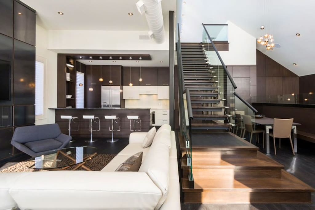 Staircase separating living room and kitchen from dining area