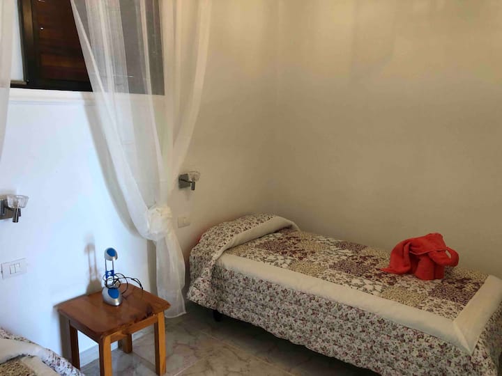 Kreveti za jednu osobu ,udobna soba s bijelom zavjesom  koja prostoriju čini jedinstvenom i mirnijom.