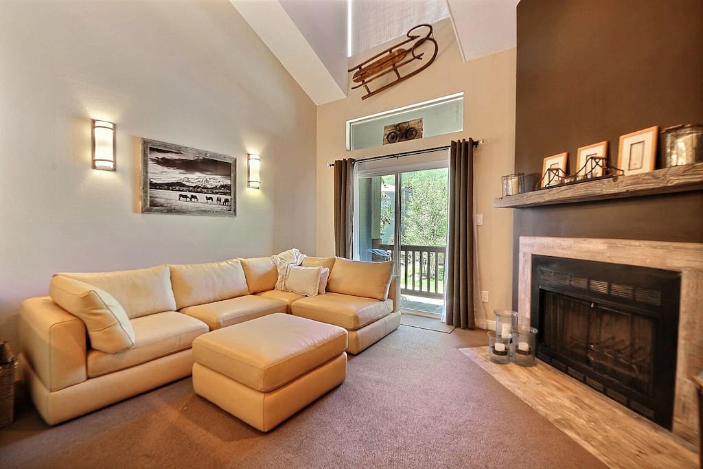 Living room features an amazingly comply leather sectional. plasma TV, and fireplace