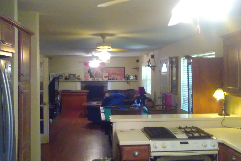 View from Kitchen to living room with sectional couch and 62 inch large screen TV with DVD Player and local HD Channels To the left you will see French Doors leading to Laundry, sun room and fenced in backyard