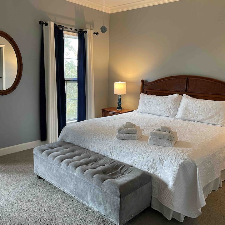 Master bedroom with king size bed and in suite bathroom with walk in shower and large tub. 