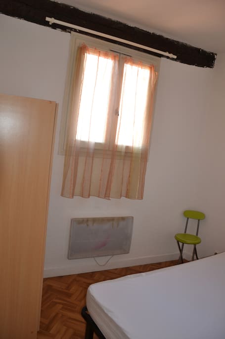 Chambre calme avec fenêtre donnant sur les toits