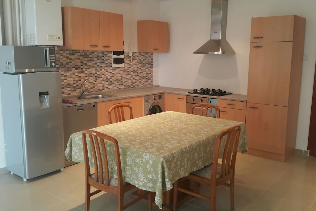 Cuisine neuve toute équipée (plaques gaz, machine à laver, lave vaisselle, frigo, micro-ondes).