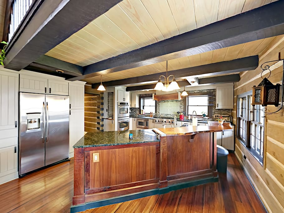 Open-concept kitchen with granite counters and stainless steel appliances, including a French-door fridge.