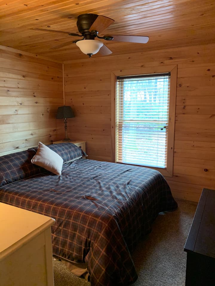 Dormitorio 1 con TV, ropa de cama y toallas.