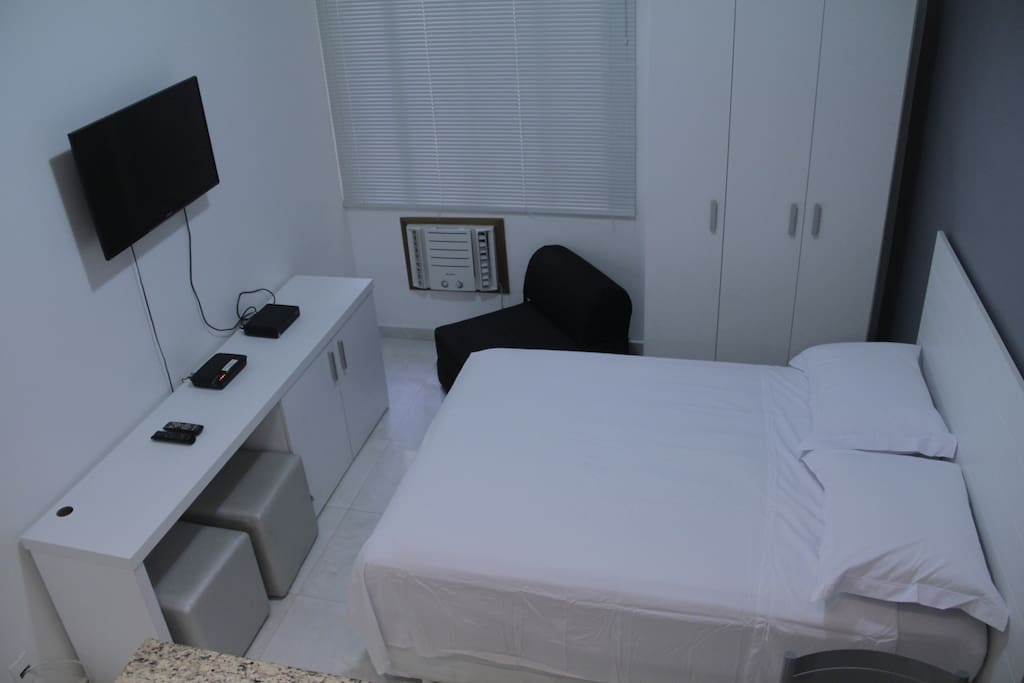Cama, armário, poltrona cama e pufes.