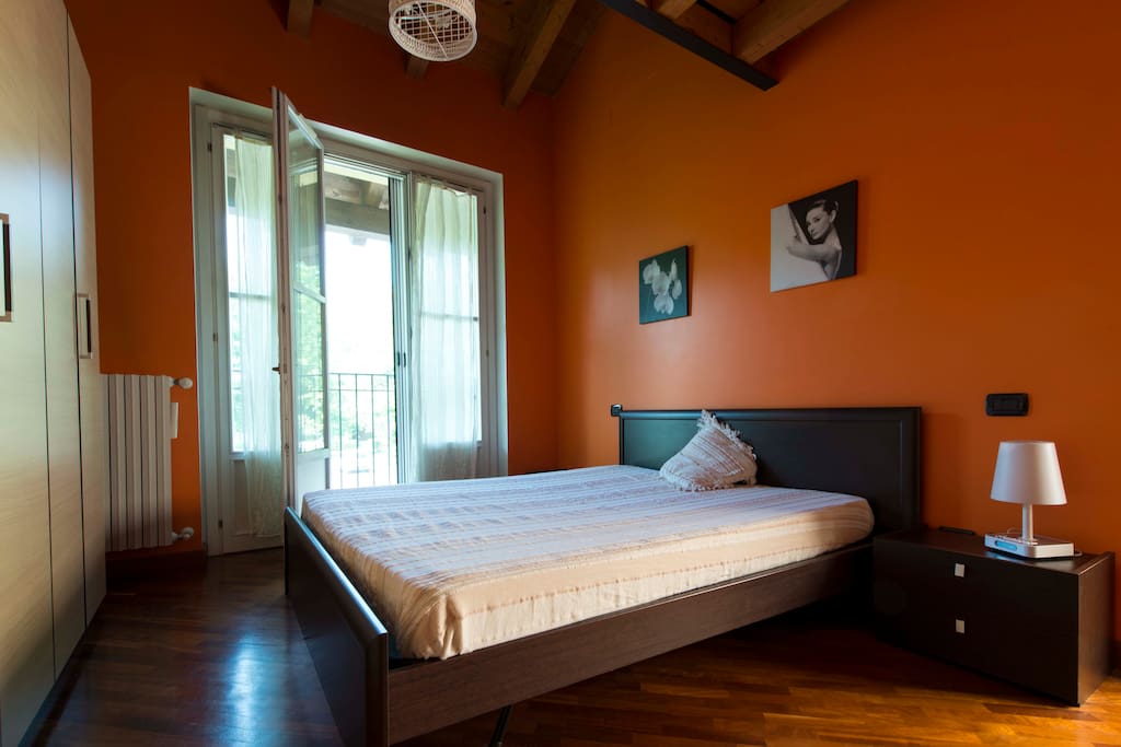 Romantica camera da letto matrimoniale con tetto in legno sfalzato e palquet.