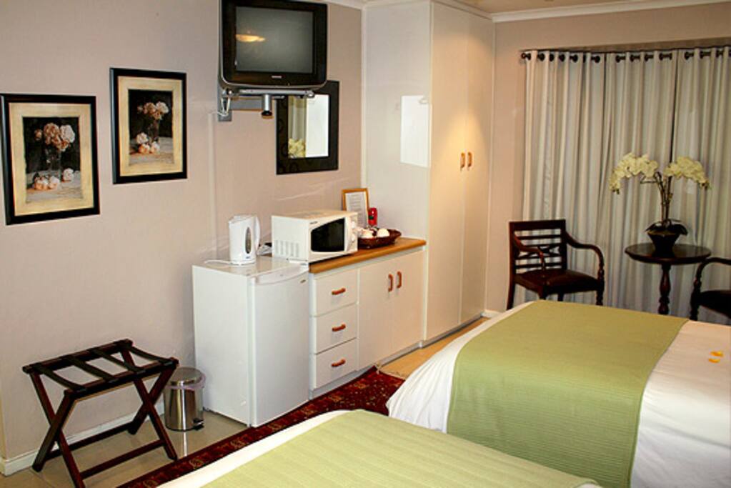 This room has a bar fridge, microwave oven , kettle as well as a shower .