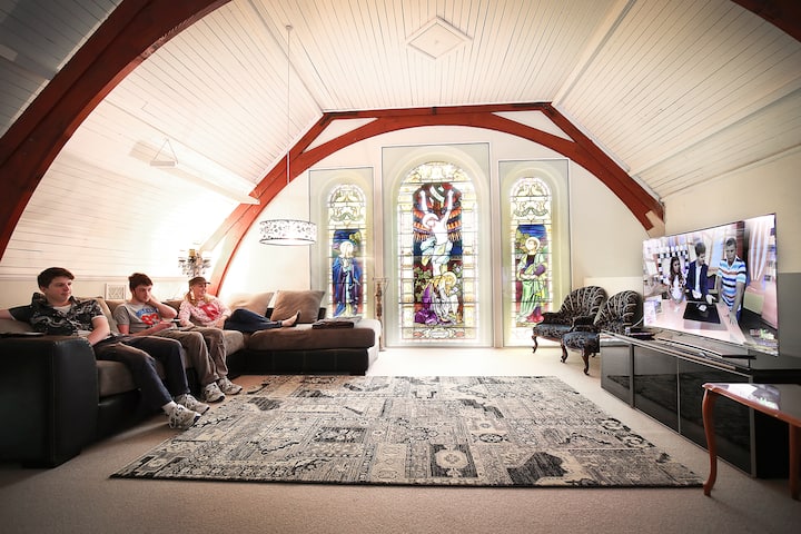 Upstairs lounge/tv room provides a comfortable lounge and entertainment area. This room allows guests to get up close to the beautiful stained glass windows. 