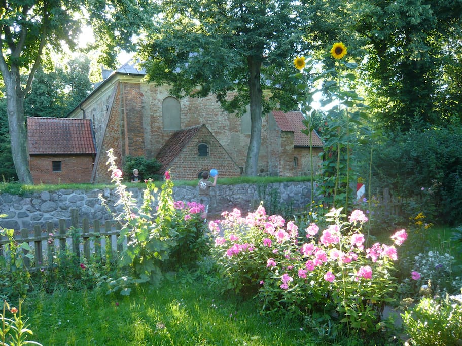 Vorgarten, im Hintergrund die Flemhuder Dorfkirche