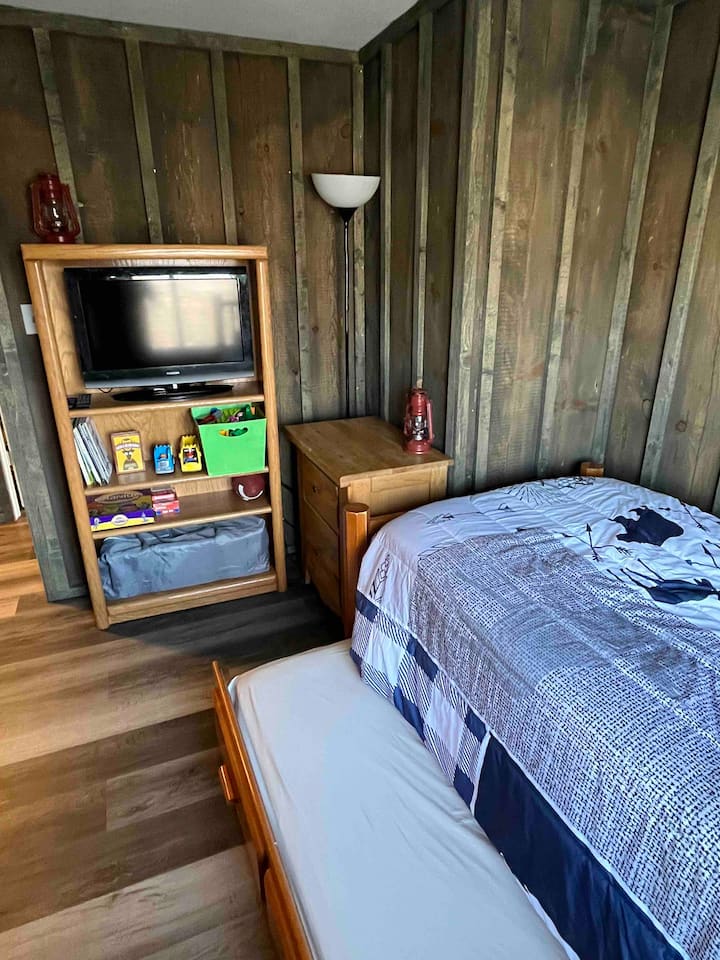 Dhomë fëmijësh me 2 krevate dopio, pako lojërash dhe televizor.