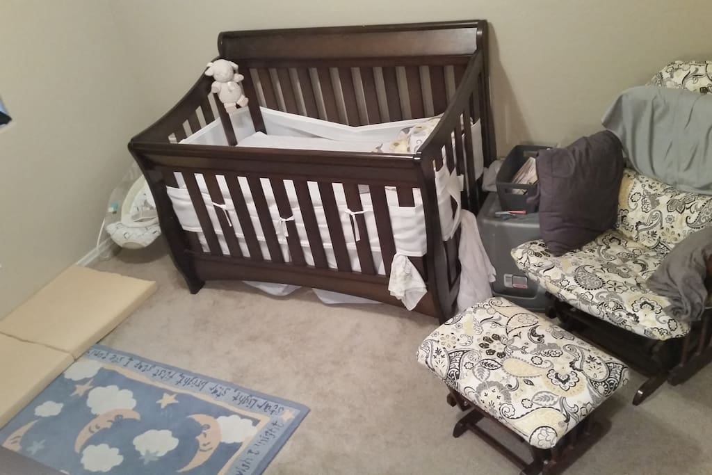 Bedroom with infant crib, changing table, and glider chair*