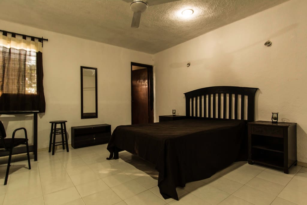 El dormitorio equipado con cama matrimonial, aire acondicionado, tocador, espejo y cajonera
